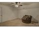 Cozy carpeted bedroom with a comfy chair, a ceiling fan, and neutral paint at 2001 Yellow Daisy Dr, Matthews, NC 28104