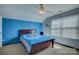 Blue bedroom with window, ceiling fan, and a bed with Carolina Panthers themed bedding at 2001 Yellow Daisy Dr, Matthews, NC 28104