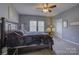 Comfortable bedroom with a ceiling fan, bedside table, and natural light from the windows at 2001 Yellow Daisy Dr, Matthews, NC 28104