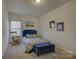 Bedroom with a blue upholstered headboard, rocking chair, and a trunk at the end of the bed at 2001 Yellow Daisy Dr, Matthews, NC 28104