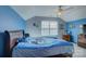 Blue bedroom with window, ceiling fan, and a bed with Carolina Panthers themed bedding at 2001 Yellow Daisy Dr, Matthews, NC 28104