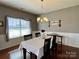 Cozy dining room is decorated with gray walls, wainscoting, and hardwood floors at 2001 Yellow Daisy Dr, Matthews, NC 28104