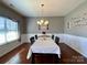 Well-lit dining room features hardwood floors, wainscoting, and a modern chandelier at 2001 Yellow Daisy Dr, Matthews, NC 28104