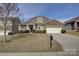 Charming home featuring a manicured lawn, stone accents, and an attached two car garage at 2001 Yellow Daisy Dr, Matthews, NC 28104