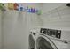 Bright laundry room with white wire shelving above front-loading washer and dryer units at 2001 Yellow Daisy Dr, Matthews, NC 28104