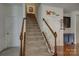 View of carpeted staircase with wooden handrail and white spindles, leading to the upper level at 2001 Yellow Daisy Dr, Matthews, NC 28104