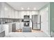 Modern kitchen featuring white shaker cabinets, stainless steel appliances, and a corner sink at 2027 Ibis Ct, Charlotte, NC 28205