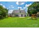 Lush backyard featuring a wooden playset and a spacious, well-maintained lawn at 247 Aylesbury Ln, Indian Trail, NC 28079
