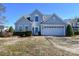 Two-story house with light gray siding, white garage door, and landscaping at 247 Aylesbury Ln, Indian Trail, NC 28079