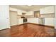 Bright kitchen featuring white cabinets, stainless steel appliances, and dark hardwood floors at 247 Aylesbury Ln, Indian Trail, NC 28079