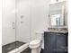 Modern bathroom featuring glass shower, sleek vanity with stone countertop and dark hardware at 2832 Arcadia Ave, Charlotte, NC 28209