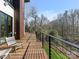 Spacious wooden deck with black metal railing overlooks a lush, wooded landscape at 2832 Arcadia Ave, Charlotte, NC 28209