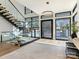 Bright foyer with open staircase, glass railings, light hardwood flooring, and modern chandelier at 2832 Arcadia Ave, Charlotte, NC 28209