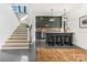 Bright kitchenette with modern cabinets, bar seating, and sleek countertops adjacent to open stairs and polished floors at 2832 Arcadia Ave, Charlotte, NC 28209