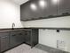 Modern laundry room features stylish gray cabinetry, sleek countertops, and a unique geometric patterned floor at 2832 Arcadia Ave, Charlotte, NC 28209