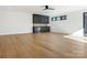 An expansive, naturally-lit living room with hardwood floors and a modern black ceiling fan at 2832 Arcadia Ave, Charlotte, NC 28209