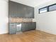 Stylish wet bar with gray cabinets, beverage fridge, and a light-colored countertop at 2832 Arcadia Ave, Charlotte, NC 28209