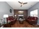 Living room with a fireplace, two red leather sofas, and hardwood floors at 3111 Hendricks Chapel Ln, Charlotte, NC 28216