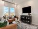 Cozy living room with a comfortable leather sofa, modern decor, and large windows at 5034 Kellaher Pl, Charlotte, NC 28216