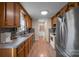 Long kitchen with wood cabinets and stainless steel appliances at 603 Helms Dr, Lowell, NC 28098