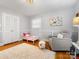 Bright bedroom with hardwood floors, a toddler bed, and a comfortable armchair at 6716 Ronda Ave, Charlotte, NC 28211