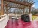 Red stained deck with pergola, table, and grill at 6716 Ronda Ave, Charlotte, NC 28211