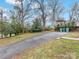 Spacious driveway with mature trees and a partially visible pergola at 6716 Ronda Ave, Charlotte, NC 28211