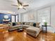 Living room with hardwood floors, L-shaped sofa, and large windows at 6716 Ronda Ave, Charlotte, NC 28211