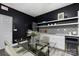 Modern kitchen features white cabinets, geometric backsplash and glass dining table at 7117 W Sugar Creek Rd, Charlotte, NC 28269