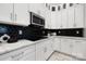 Modern kitchen with white cabinets and black hexagon backsplash at 7117 W Sugar Creek Rd, Charlotte, NC 28269