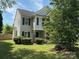 Traditional two-story house with neutral siding, black shutters, and a lush green lawn surrounded by mature trees at 8018 Trotter Rd, Charlotte, NC 28216