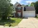 Charming two-story home featuring a brick facade, attached garage, and well-manicured front lawn at 8018 Trotter Rd, Charlotte, NC 28216