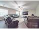 Spacious basement with leather sectional sofa, large TV, and exercise equipment at 8100 Avanti Dr, Waxhaw, NC 28173