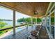 Covered porch with lake views, seating, and pool access at 8191 Deep Water Ln, Denver, NC 28037