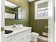 Green-walled bathroom with single vanity and toilet at 8406 Tifton Rd, Charlotte, NC 28226