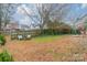 Spacious backyard with fire pit and seating area, surrounded by trees at 8708 Sweet Sage Ln, Charlotte, NC 28227