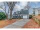 Gray house with blue door, white garage door, and tree-lined driveway at 8708 Sweet Sage Ln, Charlotte, NC 28227