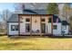 Charming farmhouse-style home with white siding, covered porch, and manicured lawn at 910 S College Ave, Newton, NC 28658