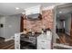 Modern kitchen with white cabinets and exposed brick wall at 910 S College Ave, Newton, NC 28658