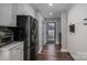 Kitchen features stainless steel fridge, access to backyard, and hardwood floors at 910 S College Ave, Newton, NC 28658