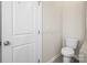 Well-lit bathroom with toilet and white door at 9223 Belcaro Ln, Charlotte, NC 28273