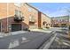 Brick townhomes featuring balconies and attached garages are neatly aligned along the community street at 9223 Belcaro Ln, Charlotte, NC 28273