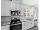 Stylish kitchen with stainless steel appliances, granite countertops, and white cabinetry at 9223 Belcaro Ln, Charlotte, NC 28273