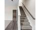 A carpeted staircase with white trim and access to a large shelved storage area at 9223 Belcaro Ln, Charlotte, NC 28273