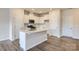 Modern kitchen with white cabinets, island, and hardwood floors at 9858 Old Garden Cir, Gastonia, NC 28056