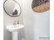 Powder room with pedestal sink, modern faucet, and circular mirror at 9862 Old Garden Cir, Gastonia, NC 28056