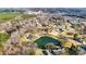 Scenic aerial view of a neighborhood with homes nestled among trees and a tranquil pond at 13031 Westmoreland Farm Rd, Davidson, NC 28036