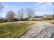 A stone and brick home has a manicured lawn and mature trees in bright sunlight at 13031 Westmoreland Farm Rd, Davidson, NC 28036