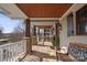 Relaxing covered porch featuring stone columns, wood ceilings, and comfortable seating at 13031 Westmoreland Farm Rd, Davidson, NC 28036