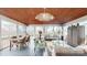 Bright and airy sunroom featuring wood ceilings, ceiling fan, dining table, and comfortable seating area at 13031 Westmoreland Farm Rd, Davidson, NC 28036